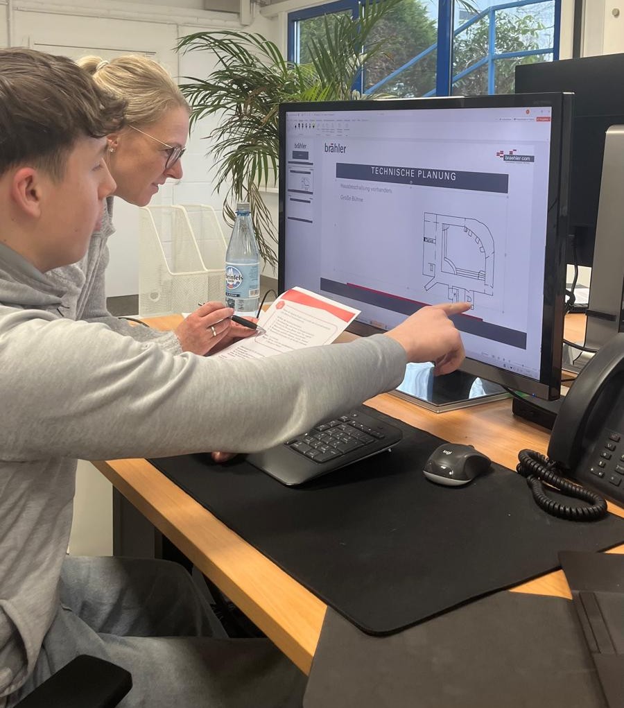 Azubi zeigt der Ausbilderin eine technische Planung auf dem Bildschirm